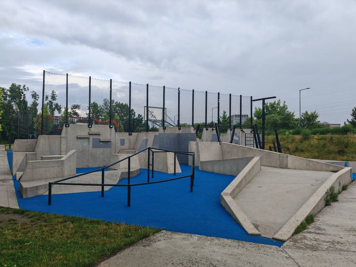 A purpose-built parkour park with low walls, bars and soft blue surfacing in Krakow