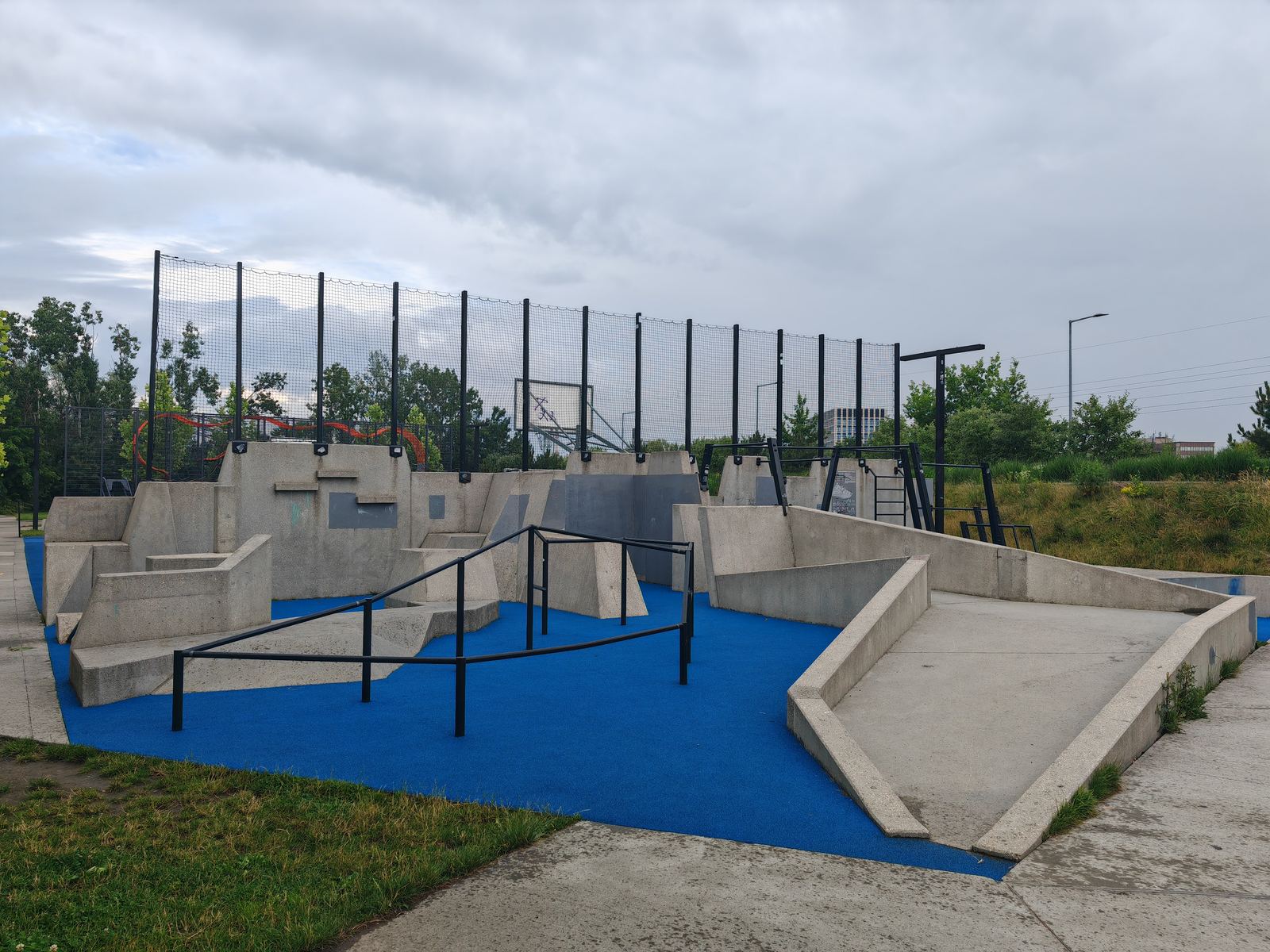 A purpose-built parkour park with low walls, bars and soft blue surfacing in Krakow